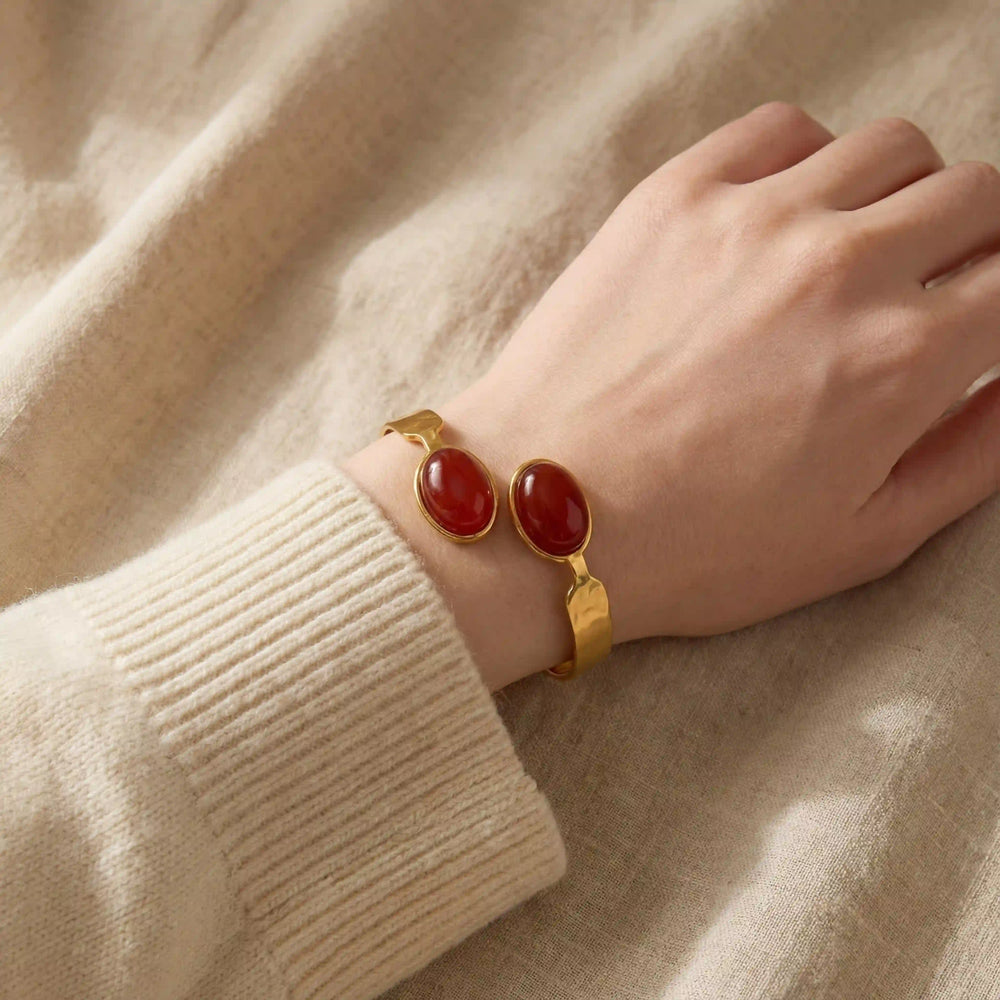 Woman wearing gold carnelian gemstone bangle with cozy beige sweater fall fashion.