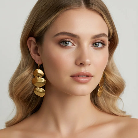 A stunning portrait of a blonde model wearing The Thalia Earrings, demonstrating their power to frame the face and add a touch of artistic flair.