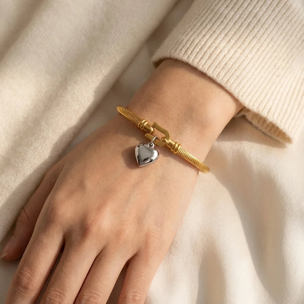 Model wearing twisted cable heart bangle aesthetic beige background lifestyle video. Main image