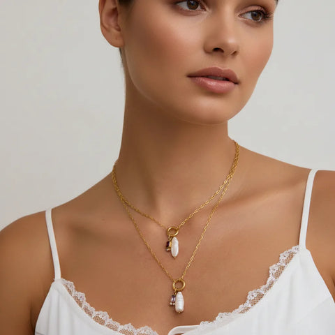 A close-up of a model wearing The Astoria Necklace with a simple white camisole, illustrating its delicate and personal feel for everyday wear.