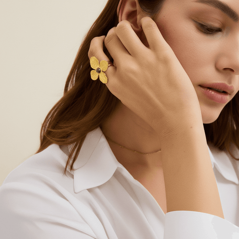 A model's hands are visible, with the Gaia Ring on one hand, complemented by several delicate, thin gold stacking rings and beaded bracelets, demonstrating a chic, layered boho look
