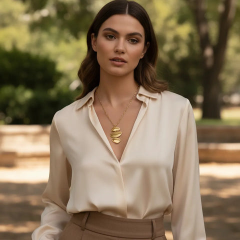 A chic model walking outdoors, with The Thalia Necklace adding a touch of modern, artistic elegance to her sophisticated style.