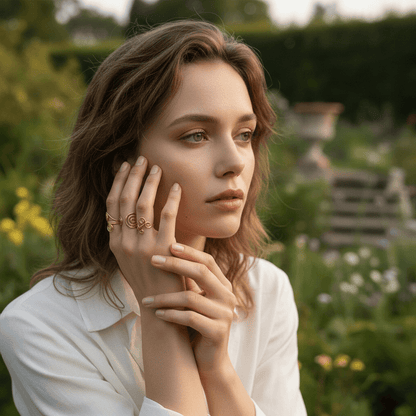 A close-up on the cuff of a model's crisp white linen shirt, with her hand positioned to showcase the bold, gold Liquid Gold Ring. The image highlights the beautiful contrast between the ring's warm metal and the shirt's classic texture.